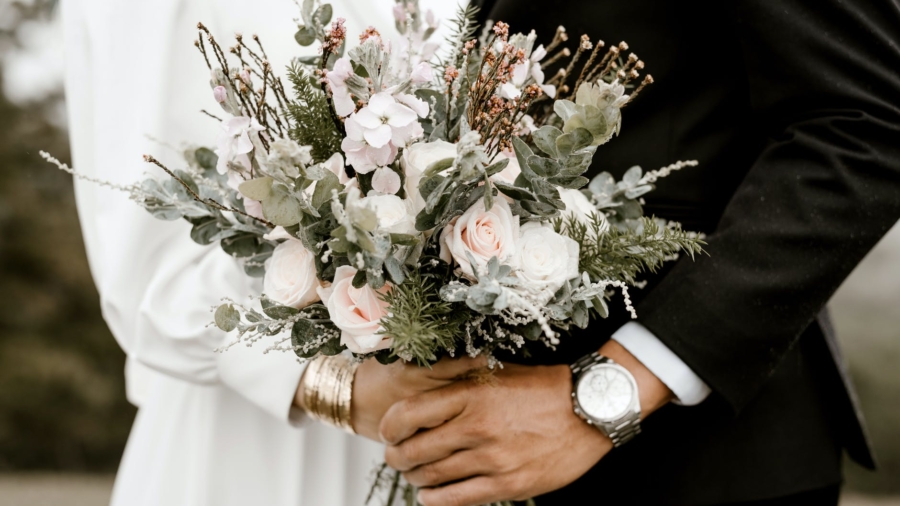 bridge and groom standing while holding flower bouquet