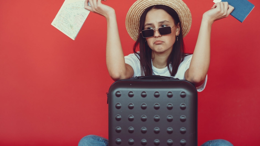 anxious young lady with tickets and passport on red background